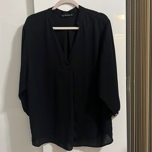 Black blouse with pearls on sleeve cuffs